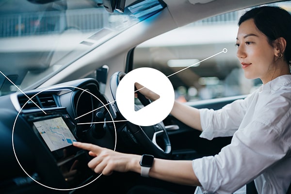 A woman sitting inside a car touching an infotainment screen